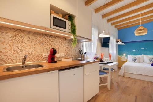 a kitchen with a sink and a bedroom with a bed at Seguidilla Relax in Gran Tarajal