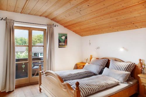 a bed in a room with a wooden ceiling at Ferienwohnung Kramernest in Grainau