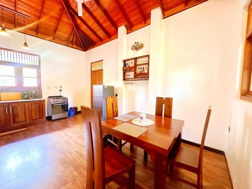 a dining room with a table and a refrigerator at Anu villa Bentota in Bentota