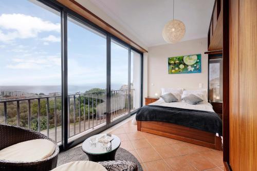 a bedroom with a bed and a large window at Casa Vale do Paraíso in Sesimbra