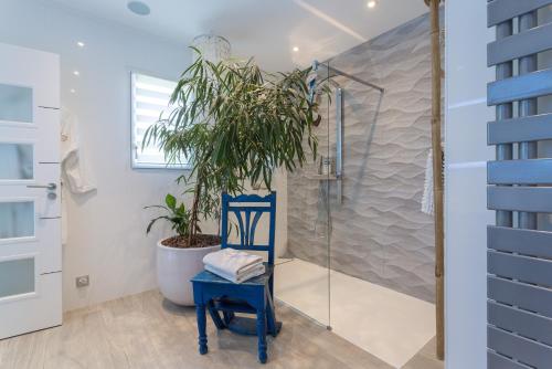 a blue chair in a bathroom with a shower at Lointaines escapades in Perpignan