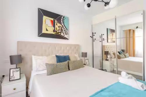 a bedroom with a large white bed and a mirror at Sunset Gabriela in Candelaria