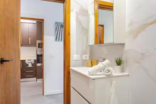 a white kitchen with a sink and a mirror at Sunset Gabriela in Candelaria