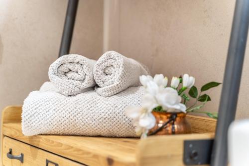 a pile of towels sitting on a table in front of a mirror at Videre Lodge Wasserfall in Gargazzone