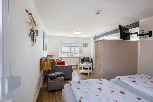 a room with two beds and a living room at Huus achtern Diek in Nordstrand