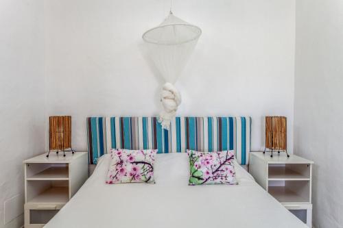 a bedroom with a white bed with two pillows at Oasis en Cotillo in Roque