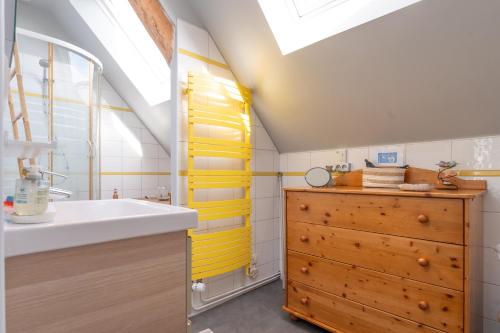 a bathroom with a sink and a wooden cabinet at La Longère d'Arzoù Chambres D'hôtes in Baden