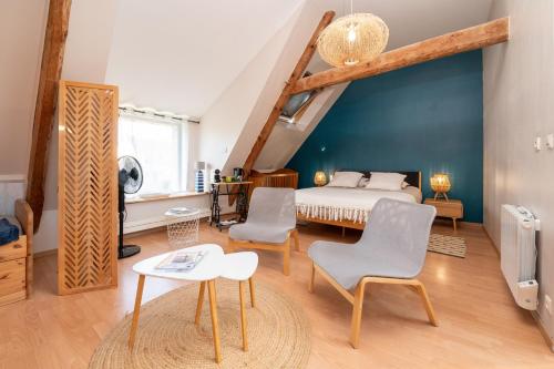 a bedroom with a bed and two chairs and a table at La Longère d'Arzoù Chambres D'hôtes in Baden