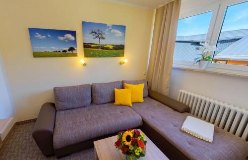 a living room with a couch with yellow pillows at Ferienhotel Mühlleithen in Klingenthal