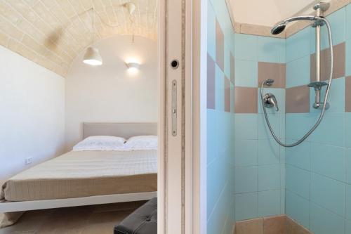 a bedroom with a bed and a shower at Trulli i Cedri, Monopoli in Monopoli