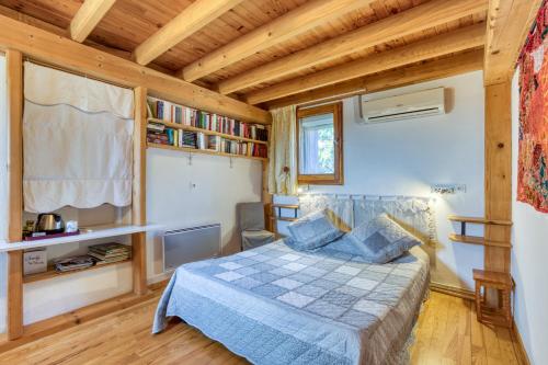 a bedroom with a bed in a room with wooden ceilings at Petite Suite Douillette - Suite in Saint-Pargoire