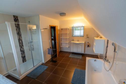a bathroom with a shower and a sink and a tub at Ferienhaus Ferienhof Behnke in Heringsdorf
