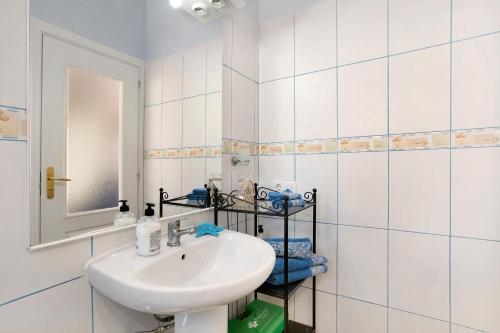 a white bathroom with a sink and a mirror at Atico Las Arenas in Arico