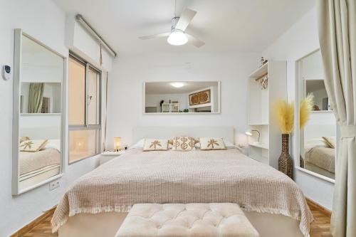a white bedroom with a large bed and mirrors at Estudio Lighthouse F77 A109 in Torrox Costa