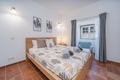 a bedroom with a bed and a blue chair at Apartamento Karolvaz V in Silves