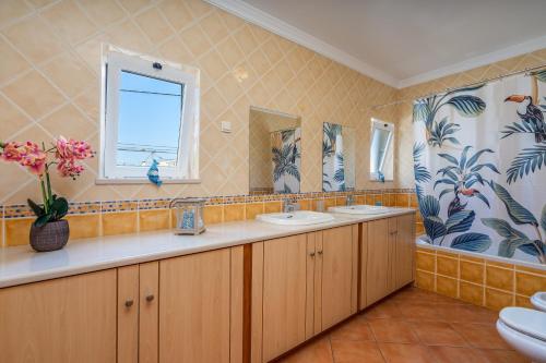 a bathroom with two sinks and a window at Poiso da Águia in Carvoeiro