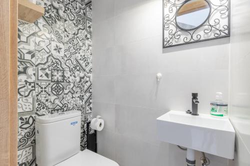 a bathroom with a toilet and a sink and a mirror at Sol y Sombra in El Campello
