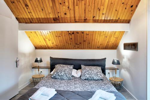 a bedroom with a large bed with wooden ceilings at Chambre D'hotes Les Tuilières in Mouleydier