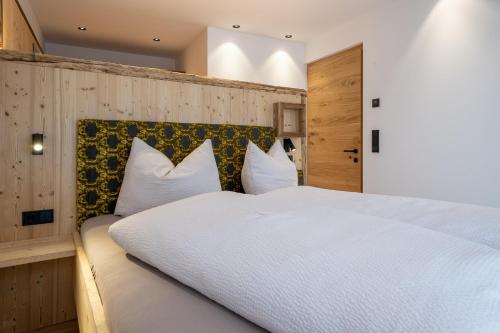 a bedroom with a large white bed with white pillows at Ladinser Hof Kuschelecke in Castelrotto
