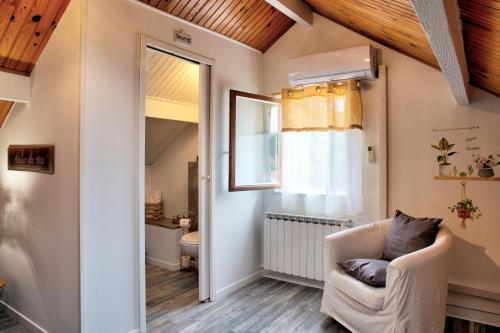 a living room with a chair and a window at Chambre D'hotes Les Tuilières in Mouleydier