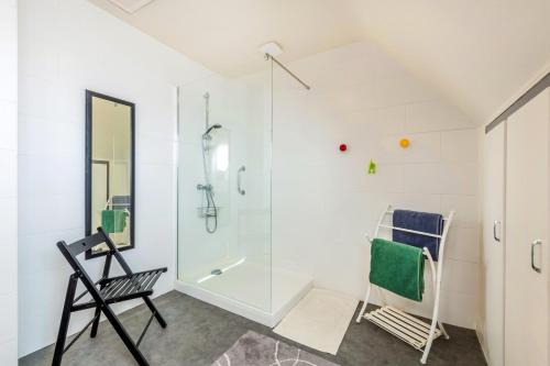 a bathroom with a glass shower and a chair at Chambre d'hôtes à Lesneven in Lesneven