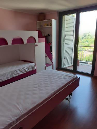 a bedroom with a bed and a large window at La Casa di Aldo 15 minuti da Torino in Pecetto