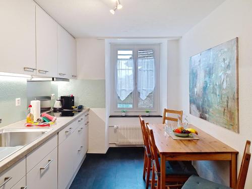 a kitchen with a wooden table and a dining room at Apartment Bieri-Haus by Interhome in Unterseen
