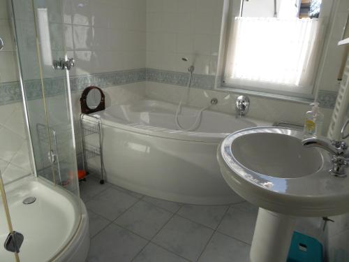 a white bathroom with a tub and a sink at Ferienwohnung Waltraud in Brilon