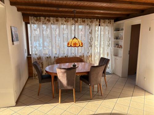 a dining room table with chairs and a chandelier at Ferienhaus Unteres Hart in Gomadingen