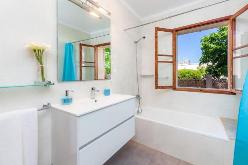 a bathroom with a sink and a tub and a window at Villa Cas Siulet in Alcudia