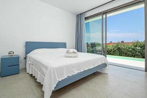 a bedroom with a bed and a large window at Villa Mirtina - by And Service in Golfo Aranci
