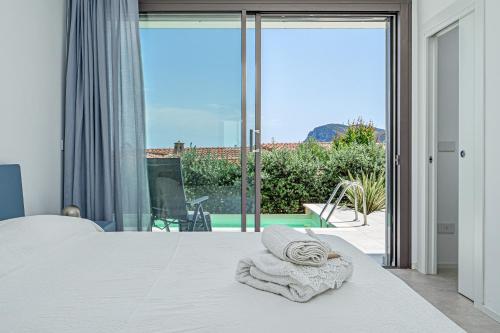 a bedroom with a bed with a towel on it at Villa Mirtina - by And Service in Golfo Aranci