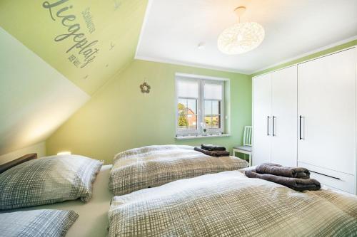 two beds in a room with green walls at Haus Ankerplatz in Wischhafen