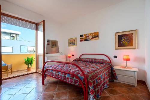 a bedroom with a bed and a large window at Villafiorita in Alghero