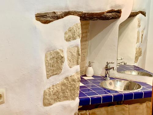 a bathroom with a sink and a stone wall at La Casuca in Olba