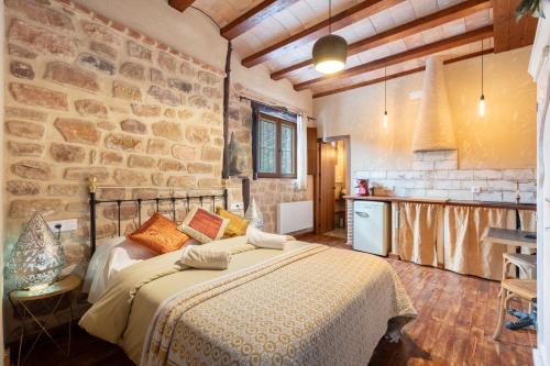 a bedroom with a bed and a stone wall at La Casuca in Olba