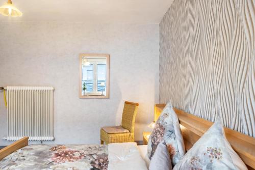 a bedroom with a bed and a window and a chair at Marisa's Sauerlandträumchen in Brilon
