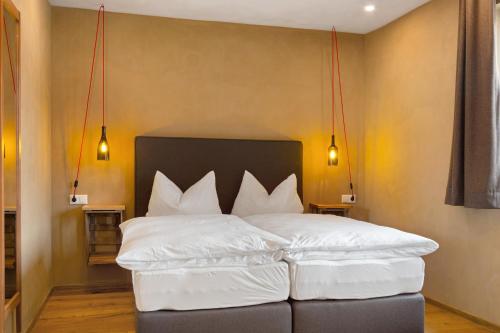 a bedroom with a bed with white pillows at Bio Bausewein - No.1 Apartment in Iphofen