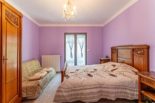 a bedroom with purple walls and a bed and a chair at Maison Avec Vue Sur Le Ventoux in Faucon