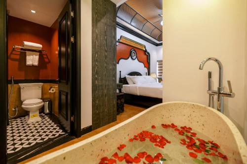 a bathroom with a toilet and a bath tub at Cao Boutique Hotel in Thôn Trường Giang
