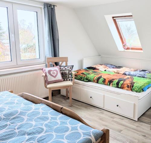 a bedroom with a bed and a chair at Ferienwohnung Waldblick in Fuhlendorf