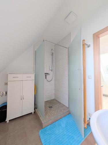 a bathroom with a shower with a blue rug at Ferienwohnung Waldblick in Fuhlendorf