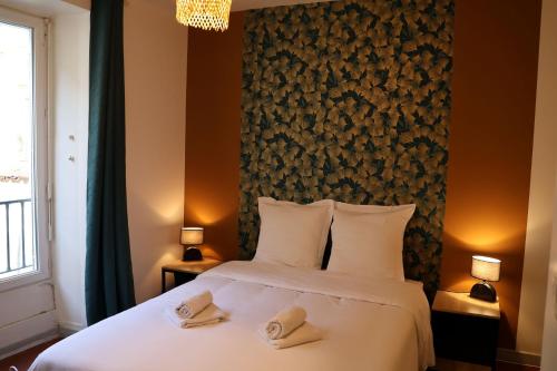 a bedroom with a bed with two towels on it at La Parenthèse Saint-Etienne- Nevers in Nevers