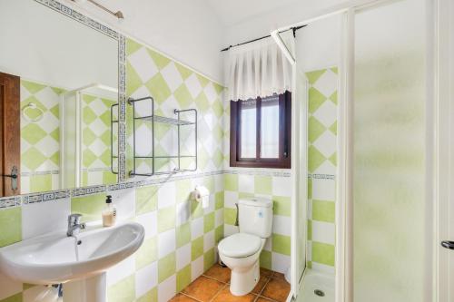 a bathroom with a toilet and a sink and a shower at Chalet El Cancelín in Conil de la Frontera