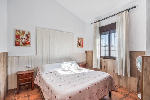 a bedroom with a bed and a window at Chalet El Cancelín in Conil de la Frontera