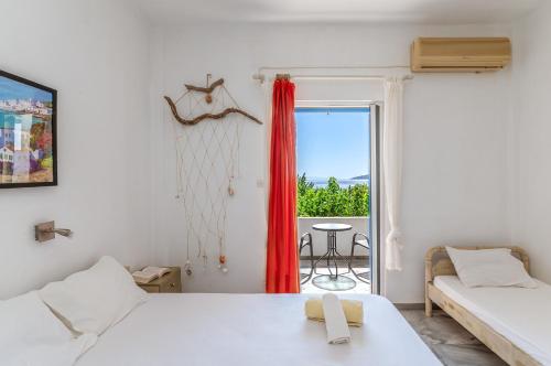 a room with two beds and a window with a table at Perasma Studio 6 in Kipri