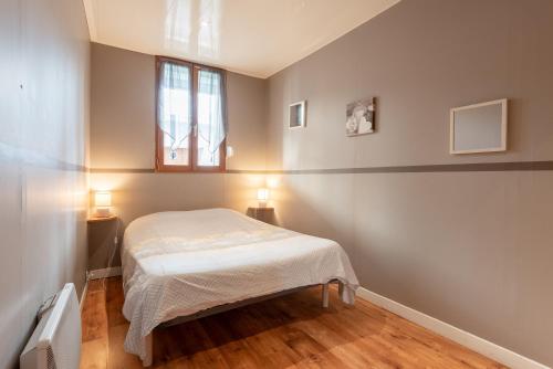 a small bedroom with a bed and a window at Appartement T2 Les Pyrénées in Bagnères-de-Bigorre