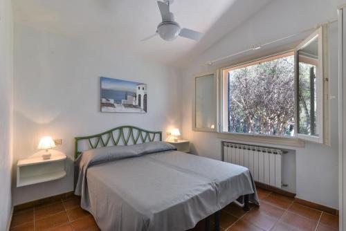 a bedroom with a bed and a window at Appartamento La Spiga in Procchio