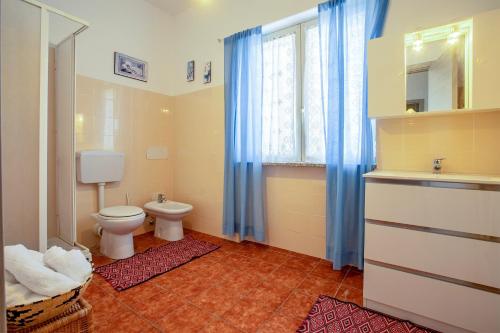 a bathroom with a toilet and a sink and a window at Casale- Il Giglio Rosa in Sorso