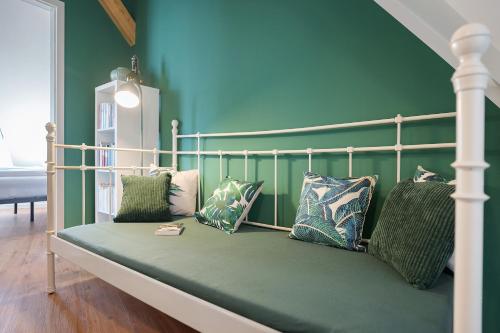 a bedroom with a bed with green walls and pillows at Remise im Wolkensteiner Hof in Gernsbach